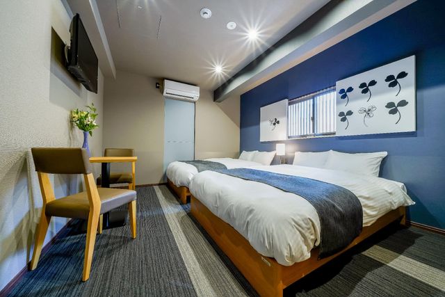 There is a desk with two chairs and a TV in the room. Air conditioner is also available.