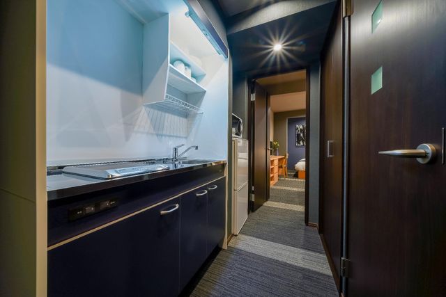 After you enter the room, you will see the small kitchen space with kitchenette, microwave, electric kettle and refrigerator.  The wash room is to the opposite side.